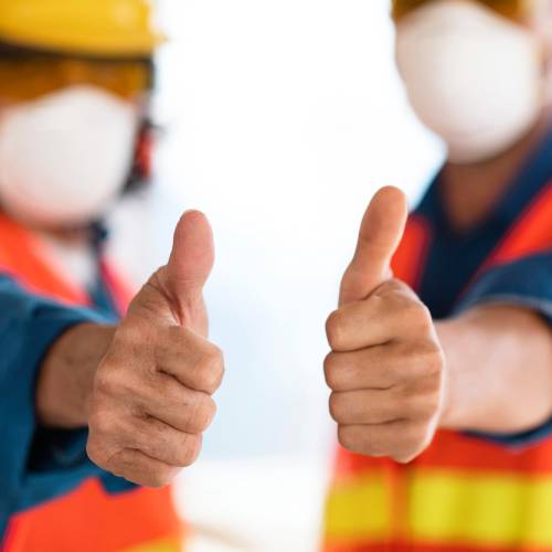 Yard workers in hard hats, face masks and high-visibility vests